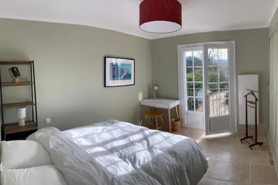 a bedroom with a bed and a table and a window at Beautiful Property Isle-sur-la-Sorgue in LʼIsle-sur-la-Sorgue