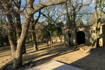 an old stone building with a tunnel in a park at Beautiful Property Isle-sur-la-Sorgue in LʼIsle-sur-la-Sorgue