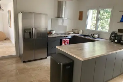 a kitchen with a stainless steel refrigerator and a counter at Beautiful Property Isle-sur-la-Sorgue in LʼIsle-sur-la-Sorgue