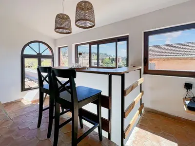 a dining room with a table and chairs and windows at Duplex centre de Roussillon avec Climatisation et vue in Roussillon