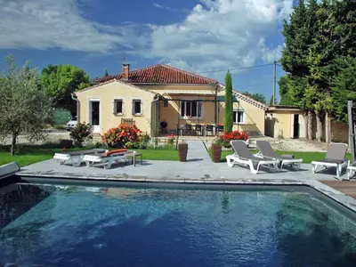 a swimming pool with chairs and a house at Holiday Home in L'Isle-sur-la-Sorgue with Pool in LʼIsle-sur-la-Sorgue