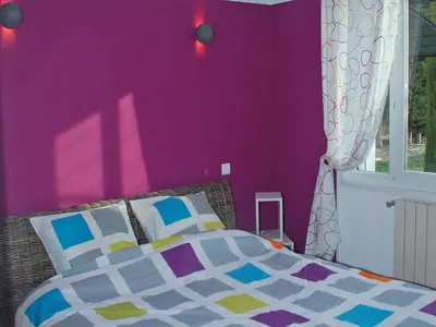 a bedroom with a purple wall and a bed at Holiday Home in L'Isle-sur-la-Sorgue with Pool in LʼIsle-sur-la-Sorgue
