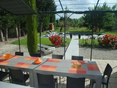 a patio with a table and chairs and a garden at Holiday Home in L'Isle-sur-la-Sorgue with Pool in LʼIsle-sur-la-Sorgue