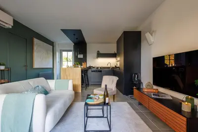 a living room with a white couch and a tv at Basti Lou - Proche du village de Gordes in Gordes