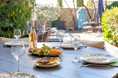 a blue table with plates of food and wine glasses at Basti Lou - Proche du village de Gordes in Gordes
