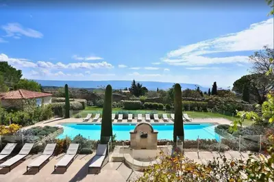 a pool with chaise lounge chairs in a garden at Basti Lou - Proche du village de Gordes in Gordes