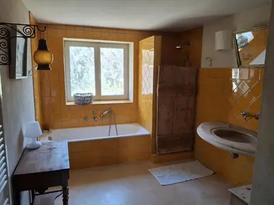 a bathroom with a tub and a sink at La Maison perchée - Mas de Rousseau in Eyragues