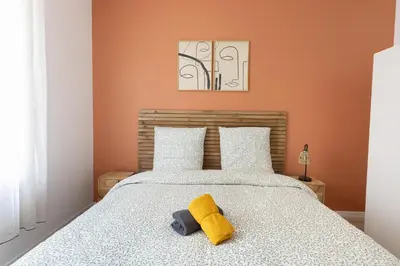 a bedroom with a bed with a yellow towel on it at Elégance en Luberon - 4 personnes - Central - Wifi in Apt