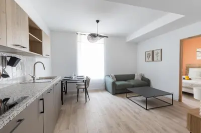 a kitchen and living room with a couch and a table at Elégance en Luberon - 4 personnes - Central - Wifi in Apt