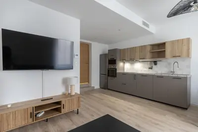 a large kitchen with a flat screen tv on a wall at Elégance en Luberon - 4 personnes - Central - Wifi in Apt