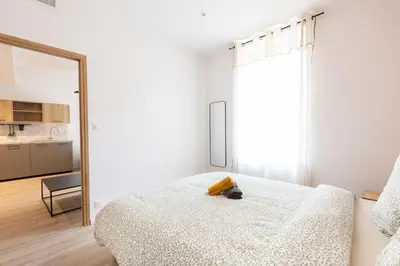 a white bedroom with a bed and a mirror at Elégance en Luberon - 4 personnes - Central - Wifi in Apt