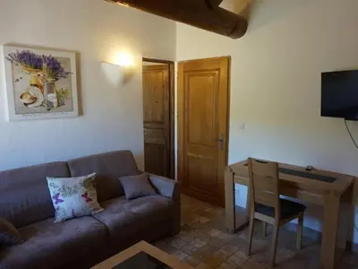 a living room with a couch and a wooden table at La Buisse in Simiane-la-Rotonde