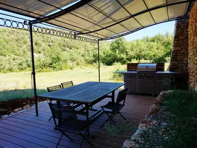 a patio with a picnic table and a grill at La Buisse in Simiane-la-Rotonde