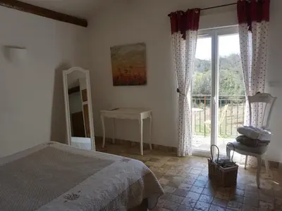 a bedroom with a bed and a desk and a window at La Buisse in Simiane-la-Rotonde