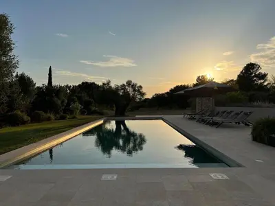 a swimming pool with a sunset in the background at EcoLodge romantique proche Lourmarin Piscine Privée Borne recharge in Puyvert