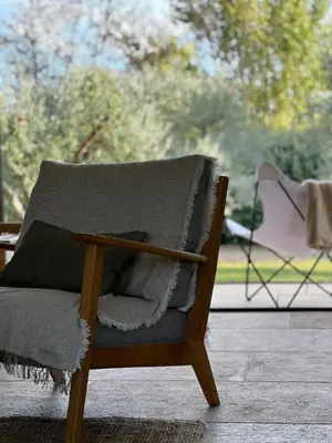 a rocking chair with a blanket on a patio at EcoLodge romantique proche Lourmarin Piscine Privée Borne recharge in Puyvert