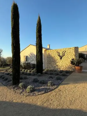 a house with three trees in front of a wall at EcoLodge romantique proche Lourmarin Piscine Privée Borne recharge in Puyvert