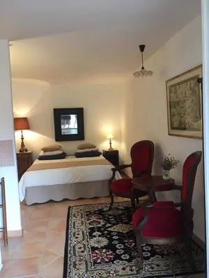 a bedroom with a bed and a table and chairs at La Bergerie Pradel in Le Beaucet