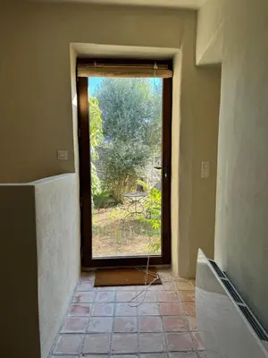 a room with a window with a view of a yard at Le charme au centre du village in Ménerbes