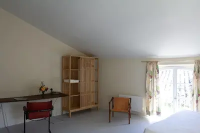 a bedroom with a bed and a desk and a window at Le charme au centre du village in Ménerbes