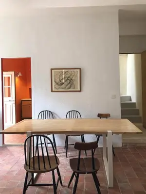a large wooden table with chairs in a room at Le charme au centre du village in Ménerbes