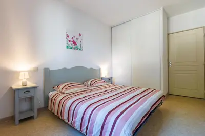 a bedroom with a bed with a striped comforter at Bastidon Provençal - Avec piscine partagée in Aubignan