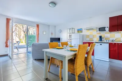 a kitchen and dining room with a table and chairs at Bastidon Provençal - Avec piscine partagée in Aubignan