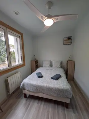 a bedroom with a bed and a ceiling fan at Maison au bord de l'eau in Le Thor