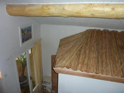 a room with a ceiling with a thatch roof at Gite Fa Mille maison bleu in Robion en Luberon