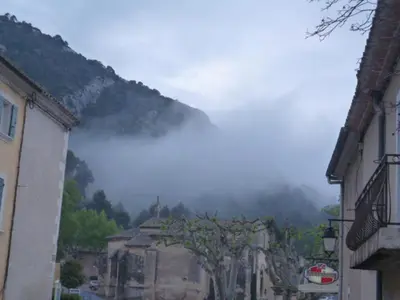 a view of a town with a mountain in the background at Gite Fa Mille maison bleu in Robion en Luberon