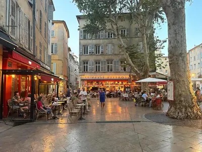 a city street with people sitting at tables and restaurants at Bel appartement aixois dans le centre historique in Aix-en-Provence