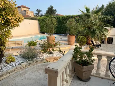 a backyard with a swimming pool and a fence with plants at Maison méditerranéenne 130m piscine Vaucluse in Carpentras