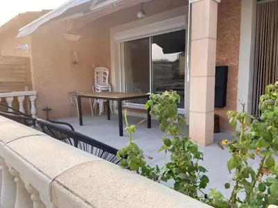 a porch with a table and a dining table at Maison méditerranéenne 130m piscine Vaucluse in Carpentras