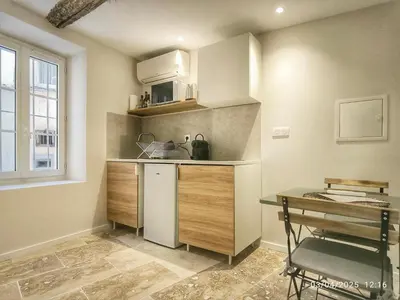 a small kitchen with a table and a chair at Le Solari - Studio lumineux au cœur du centre historique in Aix-en-Provence