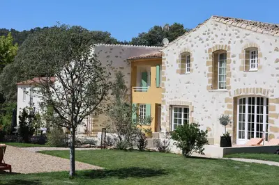 a large stone house with a tree in the yard at Domaine Robert in Rognes