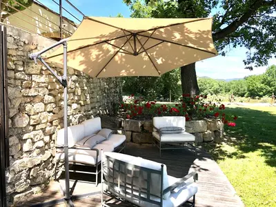 a patio with two chairs and an umbrella at Villa Provençale - Rognes campagne d'Aix en Provence in Rognes