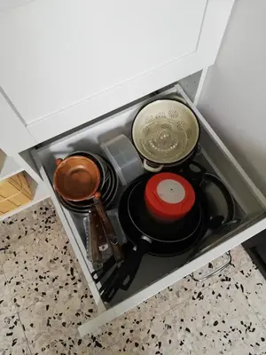 a drawer filled with pots and pans in a cabinet at Gîte de la treille in LʼIsle-sur-la-Sorgue