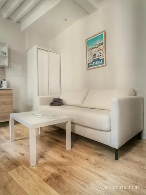 a living room with a white couch and a table at Le Mistral Studio au cœur du centre historique in Aix-en-Provence