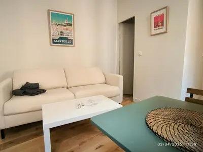 a living room with a couch and a table at Le Mistral Studio au cœur du centre historique in Aix-en-Provence