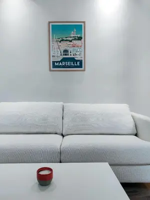 a living room with a white couch and a picture on the wall at Le Mistral Studio au cœur du centre historique in Aix-en-Provence