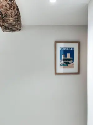 a picture hanging on a white wall in a room at Le Mirabeau studio au cœur du centre historique - 2eme étage in Aix-en-Provence