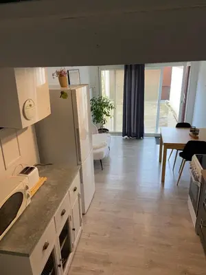 a kitchen and living room with a table and a refrigerator at Studio 1 personne Vaucluse in Carpentras