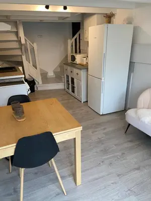 a kitchen with a table and a white refrigerator at Studio 1 personne Vaucluse in Carpentras
