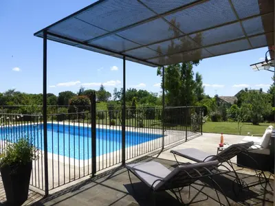 a screened in patio with chairs and a swimming pool at Charming Holiday Villa with Pool in LʼIsle-sur-la-Sorgue