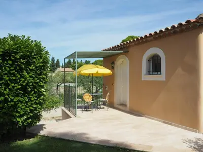 a patio with an umbrella and a table and chairs at Charming Holiday Villa with Pool in LʼIsle-sur-la-Sorgue