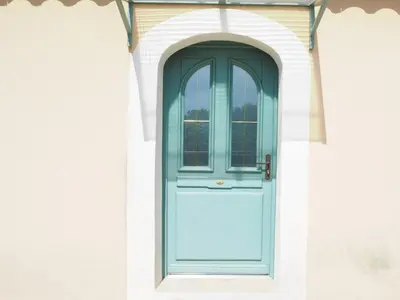 a blue door on the side of a building at Charming Holiday Villa with Pool in LʼIsle-sur-la-Sorgue