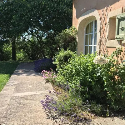 a house with a garden of flowers and a window at Domaine de la Bastidonne in Céreste