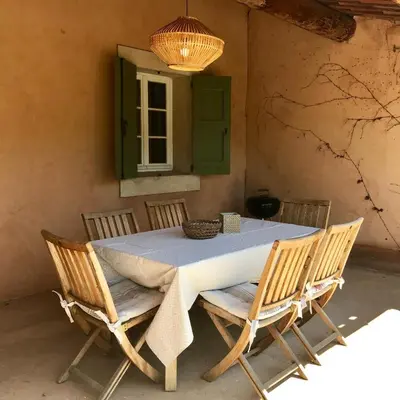 a table with four chairs and a green window at Domaine de la Bastidonne in Céreste