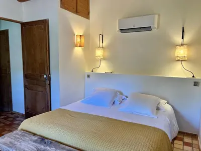 a bedroom with a bed with two pillows and a tv at Domaine de la Bastidonne in Céreste