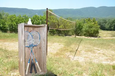 a net with two tennis rackets in a field at Domaine de la Bastidonne in Céreste